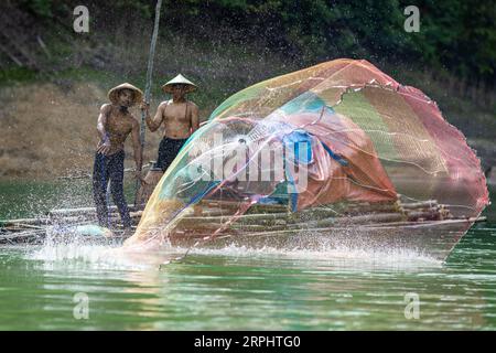 Lancia la rete da pesca al lago di Pedu situato nello stato di Kedah in Malesia Foto Stock