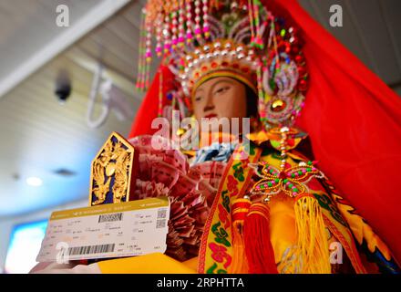 191118 -- PECHINO, 18 novembre 2019 -- foto scattata il 14 novembre 2019 mostra la statua della dea cinese Mazu e la carta d'imbarco di un aereo che la porterà in Thailandia da Xiamen, nella provincia del Fujian della Cina sud-orientale. Xinhua titoli: La dea cinese del mare Mazu visita Bangkok per scambi culturali WeixPeiquan PUBLICATIONxNOTxINxCHN Foto Stock