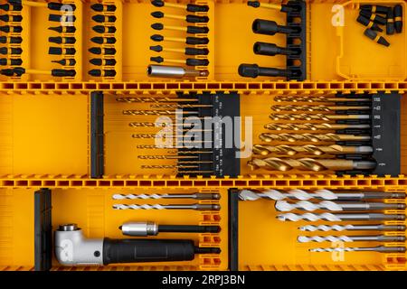 Set di punte per trapano utensili industriali professionali e attrezzature in scatola gialla. Foto Stock