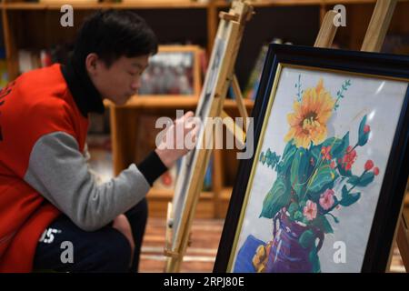 191130 -- HEFEI, 30 novembre 2019 -- Junjun, un orfano affetto da HIV/AIDS, dipinge in un centro di pittura nella città di Fuyang, nella provincia di Anhui della Cina orientale, 25 novembre 2019. È difficile collegare Junjun 18 anni con un orfano affetto da HIV/AIDS. Studiando in una scuola superiore a Fuyang, il ragazzo sfortunato ma sicuro di sé assomiglia ai suoi coetanei. Nato un bambino infetto da HIV a causa della trasmissione da madre a figlio nel 2001, Junjun è diventato orfano nel 2004 dopo che i suoi genitori sono morti di HIV/AIDS. Adottato dalla Fuyang AIDS Orphan Salvation Association, Junjun è stato in grado di ricevere la stessa istruzione dei bambini comuni e godere Foto Stock