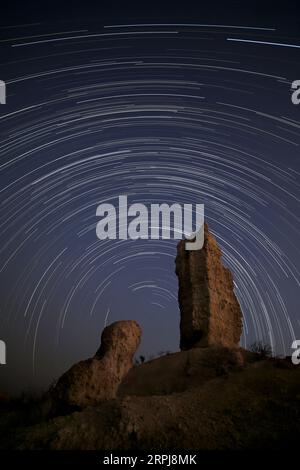 Un lungo sentiero stellare attraversa il cielo notturno sopra Vingerklipp, Damaraland, Namibia. Foto Stock