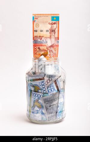 Banconote del Kazakistan di grosso taglio in una banca trasparente. Concetto di deposito bancario o credito Foto Stock