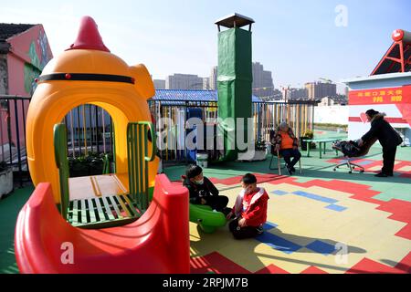 191214 -- HEFEI, 14 dicembre 2019 -- Chilren gioca nell'area di attività sul tetto di un ostello vicino all'ospedale dei bambini di Hefei, provincia di Anhui della Cina orientale, 10 dicembre 2019. Vicino all'ospedale dei bambini di Hefei, c'è un edificio rosa a due piani, che viene affittato da un'organizzazione non governativa del benessere come ostello che fornisce camere gratuite a breve termine e auto-aiuto Love Kitchen per le famiglie colpite dalla povertà con bambini in cerca di cure mediche. Nella cucina dell'amore , acqua, elettricità, riso, farina, cereali, olio e utensili da cucina sono tutti disponibili gratuitamente. Per fare la Love Kitchen Foto Stock