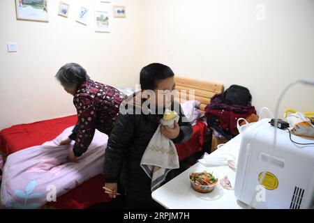 191214 -- HEFEI, 14 dicembre 2019 -- Un bambino ha un pasto in un ostello vicino al Children s Hospital di Hefei, provincia di Anhui, Cina orientale, 9 dicembre 2019. Vicino all'ospedale dei bambini di Hefei, c'è un edificio rosa a due piani, che viene affittato da un'organizzazione non governativa del benessere come ostello che fornisce camere gratuite a breve termine e auto-aiuto Love Kitchen per le famiglie colpite dalla povertà con bambini in cerca di cure mediche. Nella cucina dell'amore , acqua, elettricità, riso, farina, cereali, olio e utensili da cucina sono tutti disponibili gratuitamente. Al fine di rendere la Love Kitchen più scorrevole, genitori Foto Stock