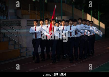 191215 -- MACAO, 15 dicembre 2019 Xinhua -- Una cerimonia di innalzamento della bandiera si tiene presso la Hou Kong Middle School di Macao, nel sud della Cina, 18 novembre 2019. Xinhua/Cheong Kam Ka Xinhua titoli: Macao, viaggio ventennale di sviluppo condiviso sulla terraferma PUBLICATIONxNOTxINxCHN Foto Stock