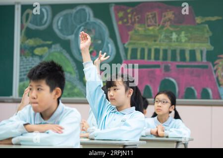 191215 -- MACAO, 15 dicembre 2019 Xinhua -- Yu in sin C alza la mano per rispondere alle domande durante una lezione alla Premier School affiliata alla Hou Kong Middle School a Macao, Cina meridionale, 25 novembre 2019. Yu di 10 anni, nato a Macao, è uno studente di quinta elementare della Premier School affiliata alla Hou Kong Middle School. Anche suo fratello studia alla scuola. Agli occhi di sua madre, Yu in sin è una ragazza ottimista, solare e vivace con molti talenti. Ha vinto molti premi nelle competizioni di narrazione, recitazione, arte e danza degli studenti delle scuole primarie di Macao. Anche se nato dopo Macao S retu Foto Stock