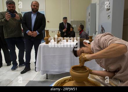 191220 -- ATENE, 20 dicembre 2019 -- i visitatori guardano un artigiano che fa un vaso alla mostra Porcelain Journey along Silk Road - On Site Performance of the Traditional Porcelain Shaping Technique ad Atene, Grecia, il 20 dicembre 2019. La mostra di oltre 100 opere d'arte in porcellana provenienti dalla Cina orientale di Jingdezhen ha aperto qui il venerdì, tra cui oggetti d'antiquariato risalenti a quattro secoli fa, nonché opere contemporanee di artigiani cinesi. GREECE-ATHENS-CHINA-PORCELAIN-EXHIBITION MariosxLolos PUBLICATIONxNOTxINxCHN Foto Stock