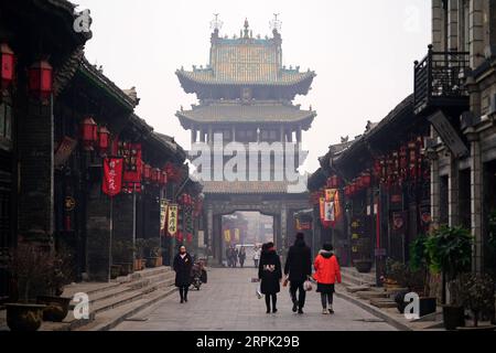 191225 -- PINGYAO, 25 dicembre 2019 -- i turisti visitano l'antica città di Pingyao a Jinzhong, nella provincia dello Shanxi della Cina settentrionale, il 25 dicembre 2019. Pingyao, patrimonio culturale dell'umanità dell'UNESCO nella provincia dello Shanxi della Cina settentrionale, è famosa per la sua architettura antica ben conservata, tra cui le mura della città. La città è cresciuta nel XIX secolo come centro finanziario della Cina, quando i mercanti dello Shanxi hanno ampliato le loro attività in tutto il paese. Ora, i composti ben conservati di questi ricchi mercanti e alcuni elementi moderni emergenti come negozi di souvenir, bar, festival fotografico e performa teatrale Foto Stock