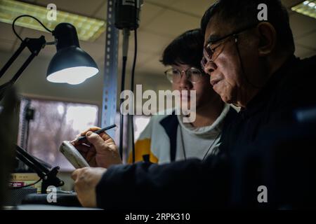 191226 -- PECHINO, 26 dicembre 2019 -- li Chunke insegna a uno studente sulla progettazione di modelli di intaglio in un workshop del Beijing Light Industry Polytechnic College di Pechino, capitale della Cina, 25 dicembre 2019. L'intaglio dei denti, che in origine significa intaglio sull'avorio, è un'arte tradizionale nell'antica Cina. Rappresentò il picco dell'arte popolare in Cina durante la dinastia Qing del 1644-1911 e divenne popolare nelle decorazioni per la corte reale. La Cina ha intensificato i suoi sforzi nella protezione della fauna selvatica nel corso degli anni. Il 31 dicembre 2016, la Cina ha dichiarato che avrebbe imposto una completa interruzione del suo commercio interno di avorio Foto Stock