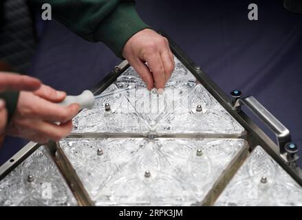 191227 -- NEW YORK, 27 dicembre 2019 -- Un operaio installa un nuovo triangolo di cristallo su un pannello sul tetto dell'edificio One Times Square a New York City, negli Stati Uniti, il 27 dicembre 2019. L'iconico ballo di Capodanno a Times Square di New York City è stato decorato il giovedì per le prossime celebrazioni, con il design Gift of Goodwill. I lavoratori hanno installato 192 nuovi triangoli di cristallo scintillante sulla palla per la sostituzione. Coperta da un totale di 2.688 triangoli di Waterford Crystal, la palla ha un diametro di 3,66 metri e pesa 11.875 libbre e 5386,4 chilogrammi. STATI UNITI-NE Foto Stock