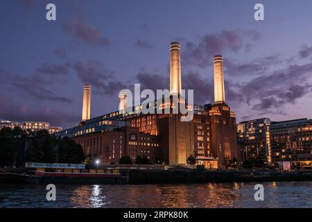 Battersea, Londra, Inghilterra - 29 luglio 2023: Calare della notte sopra gli iconici camini illuminati della centrale elettrica di Battersea ricostruita a Londra Foto Stock