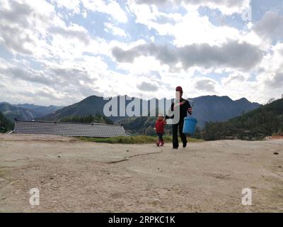 200107 -- TAIJIANG, 7 gennaio 2020 -- Un abitante del villaggio e un bambino vanno a prendere acqua di sorgente per fare vino di riso a Nanzhuang, un villaggio etnico Miao, nella Taipan Township della contea di Taijiang, nella provincia di Guizhou della Cina sud-occidentale, 6 gennaio 2020. Con l'avvicinarsi del Festival di Primavera, gli abitanti locali preparano il vino di riso secondo i costumi tradizionali e si preparano ad accogliere parenti, amici e ospiti. Foto di /Xinhua CHINA-GUIZHOU-TAIJIANG-RICE WINE-SPRING FESTIVAL CN CaixXingwen PUBLICATIONxNOTxINxCHN Foto Stock