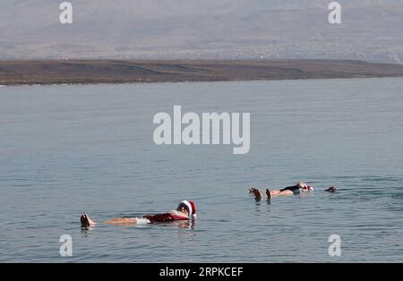 200107 -- MAR MORTO, 7 gennaio 2020 -- persone vestite come Babbo Natale galleggiano sul Mar morto, 7 gennaio 2020. Come parte di un tour di 4 giorni, 50 Santa clauses e Miss Santas hanno visitato il Mar morto martedì. Foto di Muammar Awad/Xinhua MIDEAST-DEAD SEA-BABBO NATALE ShangxHao PUBLICATIONxNOTxINxCHN Foto Stock