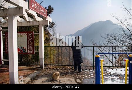 200109 -- BAOJI, 9 gennaio 2020 -- un ufficiale della stazione ferroviaria di Qingshiya fa una telefonata sul lato della scogliera con un segnale telefonico debole nella città di Baoji, nella provincia dello Shaanxi della Cina nord-occidentale, 7 gennaio 2020. La stazione ferroviaria di Qingshiya si trova sul picco dei monti Qinling sulla prima ferrovia elettrificata della Cina, Baoji - Chengdu Railway. Circondata da scogliere a strapiombo, la stazione delle nuvole è costituita da due soli binari e funge da breve sosta per i treni di passaggio sulla ferrovia. Per quanto piccola sia, la stazione ha tutti gli organi vitali. Per garantire il funzionamento della stazione ferroviaria, i membri del personale della stazione stanno lavorando Foto Stock