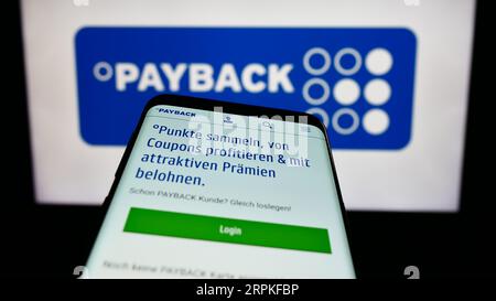 Telefono cellulare con pagina Web della società tedesca di gestione della fidelizzazione Payback GmbH sullo schermo davanti al logo. Mettere a fuoco in alto a sinistra sul display del telefono. Foto Stock