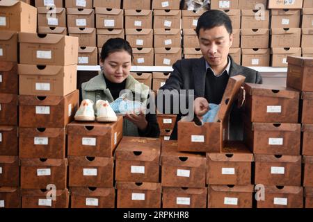 200112 -- GANGU, 12 gennaio 2020 -- Niu junjun e sua moglie Guo Juan confezionano scarpe di canapa nella loro fabbrica nella contea di Gangu, nella provincia del Gansu della Cina nord-occidentale, 10 gennaio 2020. NIU Junjun, nato nel 1987 a Gangu, ha iniziato l'attività calzaturiera insieme a sua moglie Guo Juan come risultato di una storia d'amore. NIU e Guo erano compagni di college la cui storia d'amore iniziò con un paio di scarpe di canapa Gangu, un patrimonio intangibile provinciale della città natale di Niu. Le comode e fresche scarpe estive di canapa che Niu mi ha portato hanno accresciuto il mio affetto per lui e poi ci siamo innamorati, come ha ricordato Niu. Questo regalo speciale ha ispirato il coupl Foto Stock