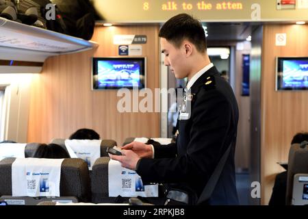 200112 -- HEFEI, 12 gennaio 2020 -- il membro dell'equipaggio del treno Liu Hengduo controlla i biglietti sul treno G24 da Hefei della provincia di Anhui della Cina orientale a Pechino, 12 gennaio 2020. Un gruppo di giovani dipendenti del personale ferroviario della sezione Hefei di China Railway Shanghai Group Co., Ltd. Ha fatto il suo debutto durante la corsa di viaggio del Festival di Primavera di recente. Cinque membri su sei di questa squadra sono nati nel 2000. Il 12 gennaio, il team post-2000 ha iniziato il suo lavoro durante la più grande migrazione annuale del paese sul treno G24 da Hefei a Pechino. Foto di /Xinhua CHINA-HEFEI-SPRING FESTIVAL-TRAVEL RUSH-SERVICE STAFF- Foto Stock