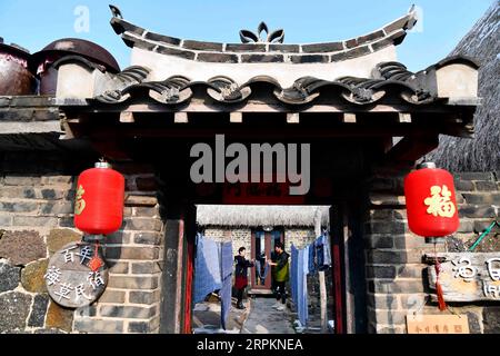 200115 -- RONGCHENG, 15 gennaio 2020 -- Yu Haiyang e sua madre foglietti d'aria nel loro cantiere nel villaggio di Yandunjiao di Rongcheng, provincia dello Shandong, Cina orientale, 12 gennaio 2020. Yandunjiao, un villaggio costiero nello Shandong, è pieno di vitalità come molti cigni invernali qui. Alla fine del 2014, è stato lanciato il servizio di treno ad alta velocità tra Qingdao e Rongcheng e numerosi turisti sono venuti qui per vedere i cigni, assaggiare le prelibatezze locali e vivere la famiglia in case con tetto di alghe. Yu Haiyang, un villaggio nativo che una volta lavorava a Singapore dopo la laurea, tornò nella città natale e iniziò una famiglia Foto Stock