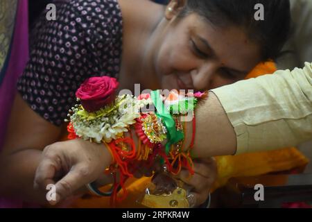 Una signora che lega rakhi e fa altri rituali al professor Tripura cm, il dottor Manik Saha, nella sua residenza ufficiale ad Agartala. Tripura, India. Foto Stock