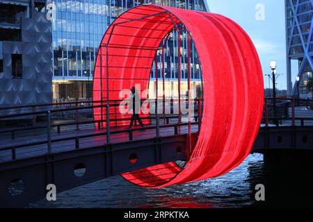 200118 -- LONDRA, 18 gennaio 2020 -- Una persona cammina attraverso un'installazione luminosa intitolata The Clew Designed by Ottotto durante uno spettacolo di luci invernali a Canary Wharf a Londra, in Gran Bretagna, 17 gennaio 2020. Foto di Tim Ireland/Xinhua BRITAIN-LONDON-LIGHTS SHOW DixMuaierlan PUBLICATIONxNOTxINxCHN Foto Stock