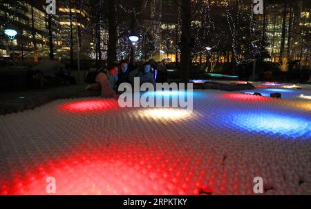 200118 -- LONDRA, 18 gennaio 2020 -- Una donna interagisce con un'installazione luminosa intitolata Pools of Light durante uno spettacolo di luci invernali a Canary Wharf a Londra, in Gran Bretagna, 17 gennaio 2020. Foto di Tim Ireland/Xinhua BRITAIN-LONDON-LIGHTS SHOW DixMuaierlan PUBLICATIONxNOTxINxCHN Foto Stock