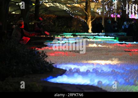 200118 -- LONDRA, 18 gennaio 2020 -- Una donna interagisce con un'installazione luminosa intitolata Pools of Light durante uno spettacolo di luci invernali a Canary Wharf a Londra, in Gran Bretagna, 17 gennaio 2020. Foto di Tim Ireland/Xinhua BRITAIN-LONDON-LIGHTS SHOW DixMuaierlan PUBLICATIONxNOTxINxCHN Foto Stock