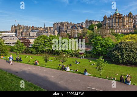 Edimburgo, Scozia, Regno Unito - 13 maggio 2023 - le persone si rilassano sul prato nei Princes Street Gardens, nel centro della città in primavera, sotto la città vecchia. Foto Stock