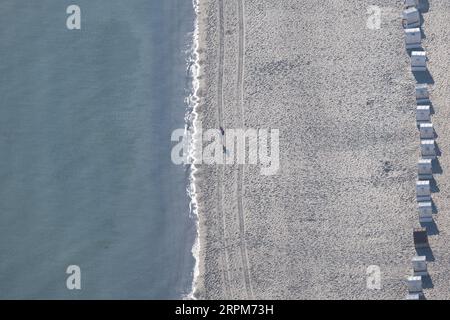 Timmendorfer Strand, Germania. 5 settembre 2023. Una persona si trova su una spiaggia vuota tra il Mar Baltico e una fila di sdraio (vista aerea dall'elicottero). Credito: Sebastian Gollnow/dpa/Alamy Live News Foto Stock