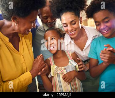 Famiglia multi-generazione che celebra il compleanno di nipote a casa Foto Stock