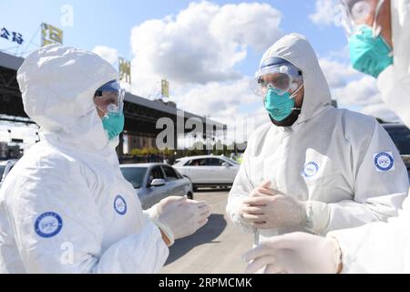 200208 -- WENZHOU, 8 febbraio 2020 -- Abdul Zahir Hamad 2nd L pakistano e sua moglie Mauritian Hosany Sumayyah L discutono con un collega di un passeggero con temperatura corporea anomala in un nuovo checkpoint di prevenzione e controllo del coronavirus di un'uscita autostradale a Wenzhou, nella provincia dello Zhejiang della Cina orientale, 8 febbraio 2020. Abdul Zahir Hamad e Mauritian Hosany Sumayyah, una coppia sposata, lavorano entrambi come medici al Panhealth Medical Center di Wenzhou. Fin dallo scoppio del nuovo coronavirus, hanno servito come volontari in un checkpoint di uscita dell'autostrada a Wenzhou, controllando l'identità Foto Stock