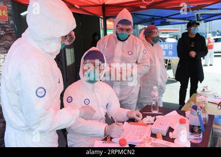 200208 -- WENZHOU, 8 febbraio 2020 -- pakistani Abdul Zahir Hamad 3rd L e sua moglie Mauritian Hosany Sumayyah 1st L registrano informazioni di persone controllate in un nuovo checkpoint di prevenzione e controllo del coronavirus di un'uscita autostradale a Wenzhou, provincia dello Zhejiang della Cina orientale, 8 febbraio 2020. Abdul Zahir Hamad e Mauritian Hosany Sumayyah, una coppia sposata, lavorano entrambi come medici al Panhealth Medical Center di Wenzhou. Fin dallo scoppio del nuovo coronavirus, hanno servito come volontari in un checkpoint di uscita dell'autostrada a Wenzhou, controllando le informazioni sull'identità e misurando il corpo te Foto Stock