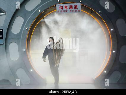 200213 -- PECHINO, 13 febbraio 2020 -- un emloyee cammina attraverso un cancello di disinfezione prima di lasciare l'area di lavoro del Chongqing Mexin Group nel comune di Chongqing della Cina sud-occidentale, 12 febbraio 2020. XINHUA FOTO DEL GIORNO LiuxChan PUBLICATIONxNOTxINxCHN Foto Stock