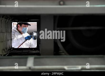 200213 -- PECHINO, 13 febbraio 2020 -- addetto alla manutenzione Zhang Zewei pulisce il trasformatore principale per il compartimento delle attrezzature di un treno presso la stazione di manutenzione ferroviaria ad alta velocità di Zhengzhou a Zhengzhou, Cina centrale, provincia di S Henan, 12 febbraio 2020. XINHUA FOTO DEL GIORNO LixAn PUBLICATIONxNOTxINxCHN Foto Stock