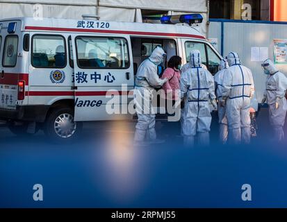 200213 -- PECHINO, 13 febbraio 2020 -- il personale medico riceve un paziente infettato dal nuovo coronavirus presso l'ospedale temporaneo convertito dal Wuhan Sports Center di Wuhan, provincia di Hubei, Cina centrale, 12 febbraio 2020. XINHUA FOTO DEL GIORNO XiaoxYijiu PUBLICATIONxNOTxINxCHN Foto Stock