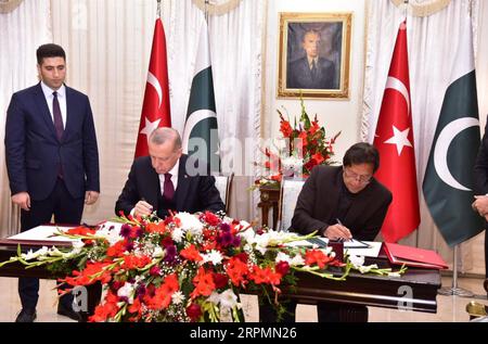 200214 -- ISLAMABAD, 14 febbraio 2020 -- la foto rilasciata dal Dipartimento di informazione della stampa pakistana mostra il primo ministro pakistano Imran Khan R e il presidente turco Recep Tayyip Erdogan C firmare una dichiarazione congiunta durante una cerimonia a Islamabad, capitale del Pakistan, il 14 febbraio 2020. Il Pakistan e la Turchia hanno firmato qui venerdì un quadro economico strategico SEF, che promuove le relazioni commerciali ed economiche per l'ulteriore dialogo sull'accordo di libero scambio. /Handout via Xinhua PAKISTAN-ISLAMABAD-TURCHIA-COOPERAZIONE PID PUBLICATIONxNOTxINxCHN Foto Stock