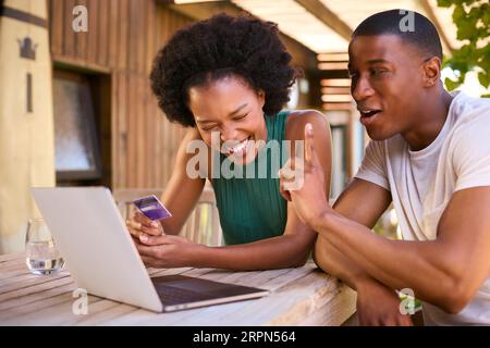 Siamo entusiasti di abbinare la carta di credito a casa per prenotare una vacanza o fare acquisti online Foto Stock