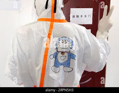 200223 -- WUHAN, 23 febbraio 2020 -- foto non datata mostra un membro dello staff medico che mostra il disegno sulla tuta protettiva nel reparto di isolamento dei bambini infettati da nuova polmonite da coronavirus nell'ospedale dei bambini di Wuhan a Wuhan, nella provincia centrale di Hubei della Cina. Nel reparto di isolamento dei bambini infettati da nuova polmonite da coronavirus nell'ospedale pediatrico di Wuhan, molti bambini avevano paura di vedere il personale medico avvolto in tute protettive. Wang Jia, un'infermiera dell'ospedale a cui piace disegnare, ha avuto l'idea di disegnare cartoni animati sulle tute protettive e invitare i bambini a cooperare Foto Stock