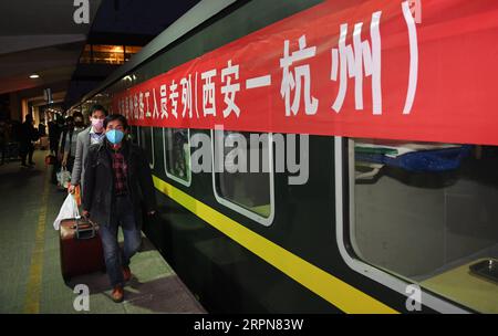 200224 -- XI AN, 24 febbraio 2020 -- lavoratori migranti della contea di Luonan sali a bordo di un treno speciale per Hangzhou alla stazione ferroviaria di Xi An, a Xi An, provincia dello Shaanxi della Cina nord-occidentale, 24 febbraio 2020. Un totale di 951 lavoratori migranti dalla contea di Luonan lunedì hanno preso il treno speciale per riprendere il lavoro nella regione del delta del fiume Yangtze. CHINA-XI AN-SPECIALE LAVORATORE FERROVIARIO MIGRANTE CN LIXYIBO PUBLICATIONXNOTXINXCHN Foto Stock