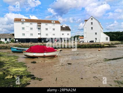 Il famoso mulino a marea a Woodbridge nel Suffolk, visto attraverso il fango del porto durante la bassa marea in una luminosa giornata estiva. Foto Stock