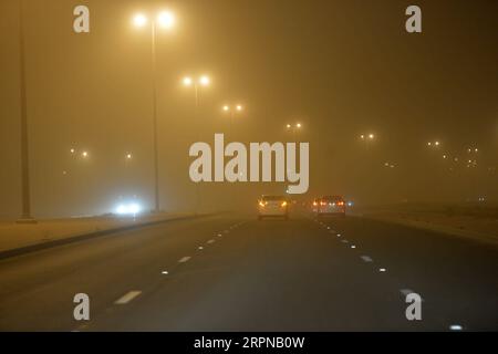 200225 -- KUWAIT, 25 febbraio 2020 -- le auto guidano in polvere pesante a Kuwait City, Kuwait, 25 febbraio 2020. Una forte tempesta di sabbia ha colpito il Kuwait martedì. Foto di Asad/Xinhua KUWAIT-KUWAIT CITY-SANDSTORM NiexYunpeng PUBLICATIONxNOTxINxCHN Foto Stock