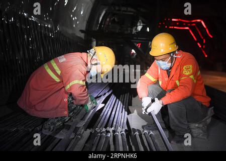 200229 -- CHONGQING, 29 febbraio 2020 -- i lavoratori lavorano in un cantiere di Zengjiayan Tunnel nel nel distretto di Yuzhong, nella municipalità di Chongqing della Cina sud-occidentale il 29 febbraio 2020. La costruzione di grandi progetti locali è stata ripresa con misure rigorose adottate per prevenire e controllare la nuova epidemia di coronavirus. CHINA-CHONGQING-COSTRUZIONE-RIPRESA CN WangxQuanchao PUBLICATIONxNOTxINxCHN Foto Stock