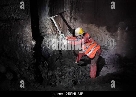 200229 -- CHONGQING, 29 febbraio 2020 -- Un lavoratore lavora in un cantiere del tunnel di Zengjiayan nel distretto di Yuzhong, nel comune di Chongqing della Cina sud-occidentale il 29 febbraio 2020. La costruzione di grandi progetti locali è stata ripresa con misure rigorose adottate per prevenire e controllare la nuova epidemia di coronavirus. CHINA-CHONGQING-COSTRUZIONE-RIPRESA CN WangxQuanchao PUBLICATIONxNOTxINxCHN Foto Stock