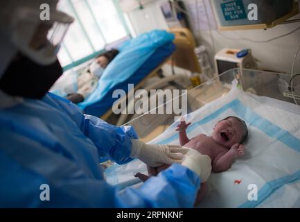 200301 -- WUHAN, 1 marzo 2020 -- l'ostetrica Wu Dan si prende cura del bambino di Liu Ting nella sala parto dell'ospedale di Wuhan per la salute materna e infantile a Wuhan, provincia di Hubei, Cina centrale, 1 marzo 2020. La mattina presto del febbraio 29, il volontario Wang Zhen ha scacciato dalla sua comunità subito dopo aver ricevuto una richiesta di aiuto da una donna incinta che viveva a 30 chilometri di distanza in un'altra comunità di Wuhan. Wang ha portato la donna incinta e la sua famiglia al Wuhan Maternal and Child Health Hospital, dove la donna ha poi dato alla luce il suo bambino. Il 23 gennaio, Wang Zhen, un programmatore di computer, j Foto Stock