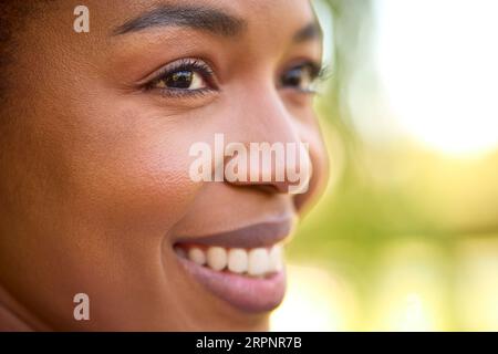 Primo piano Ritratto di una bella donna sorridente in piedi all'aperto Foto Stock