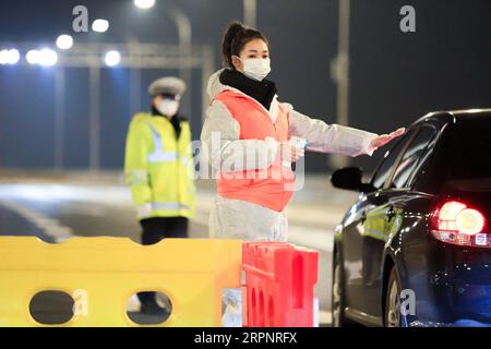 200304 -- PECHINO, 4 marzo 2020 -- il volontario Hua YuchenR si prepara a controllare la temperatura corporea dei passeggeri a Wuhan, provincia di Hubei, Cina centrale, 28 gennaio 2020. Xinhua titoli: Everyday Heroes: Migliaia di volontari si fanno avanti nella lotta contro il coronavirus contro XiaoxYijiu PUBLICATIONxNOTxINxCHN Foto Stock