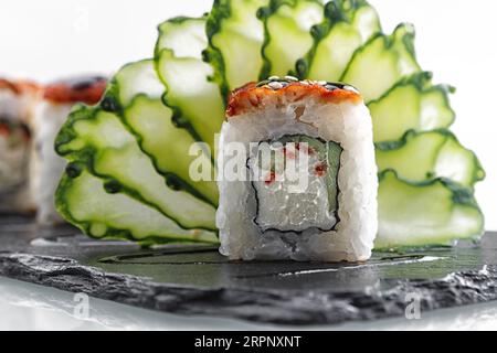 Drago Sushi Roll, su pietra nera, su sfondo bianco Foto Stock