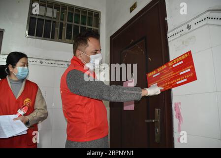 200307 -- YIWU, 7 marzo 2020 -- Hamid Dehgh R incolla un manifesto multilingue sulla prevenzione epidemica sul muro di una casa residente straniera nella Comunità Jimingshan di Yiwu, provincia di Zhejiang della Cina orientale, 6 marzo 2020. La Comunità Jimingshan della città di Yiwu, con quasi 1.400 uomini d'affari stranieri provenienti da 74 paesi, è chiamata comunità delle Nazioni Unite . Hamid Dehgh, un uomo d'affari iraniano di 55 anni, svolge attività commerciali a Yiwu dal 2003. Dopo lo scoppio della nuova malattia da coronavirus COVID-19, è diventato uno dei 39 volontari stranieri dell'epidemia straniera della comunità Foto Stock