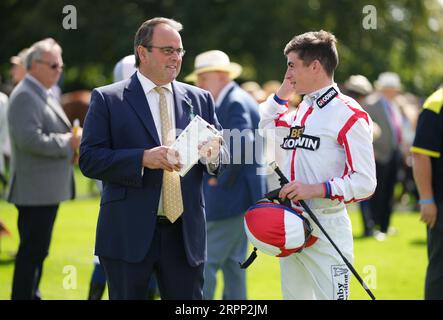 Allenatore del Mount Olympus, Alan King parla con il fantino Rossa Ryan in vista della gara di handicap "Keep Your Raceday positive" all'ippodromo di Goodwood, Chichester. Data immagine: Martedì 5 settembre 2023. Foto Stock
