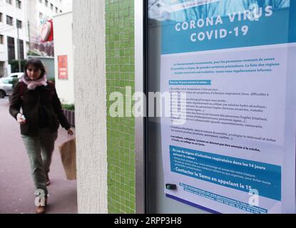 200310 -- PARIGI, 10 marzo 2020 -- Una donna passa davanti a un poster con informazioni sul controllo del coronavirus a Clichy, Francia, 9 marzo 2020. La Francia ha confermato 1.412 casi di infezione da coronavirus e 25 pazienti sono morti del virus alle 15:00, 1400 GMT lunedì, ha annunciato il Direttore generale della salute Jerome Salomon. INFEZIONE DA FRANCE-PARIS-CORONAVIRUS GaoxJing PUBLICATIONxNOTxINxCHN Foto Stock