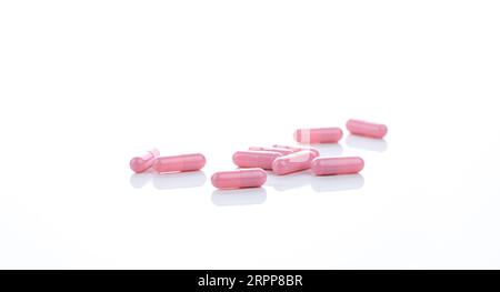 Pillole di capsule rosa su sfondo bianco. Industria farmaceutica. Concetto di vitamine, minerali e integratori. Prodotti farmaceutici. Medico farmaceutico Foto Stock